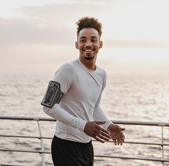 A man stands on a boat, extending his arm outward as if reaching for something in the distance.