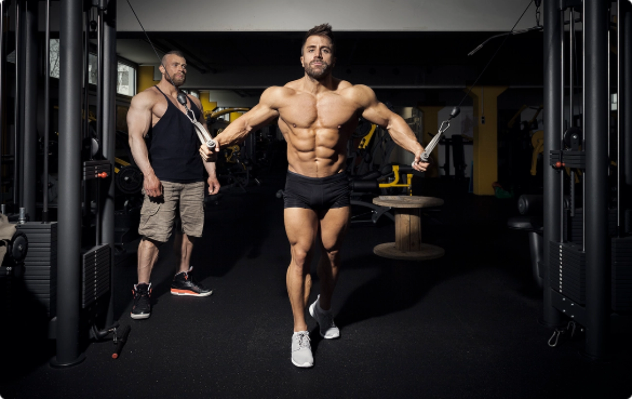 A man stands in front of a gym machine, preparing to begin his workout routine.