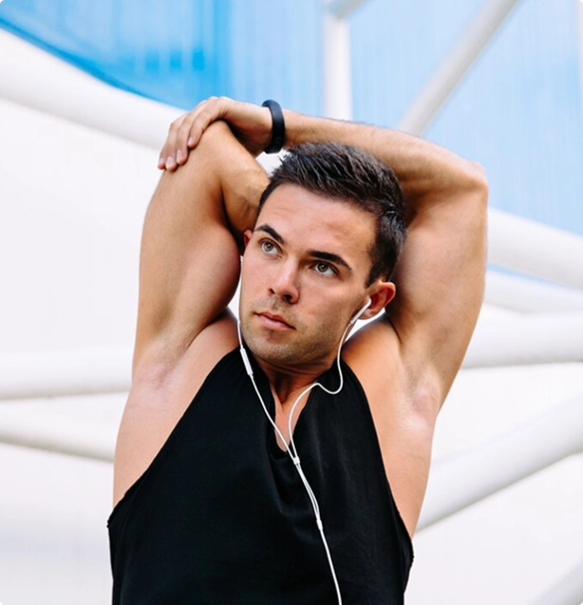 A man extends his arms while listening to music, appearing relaxed and focused.