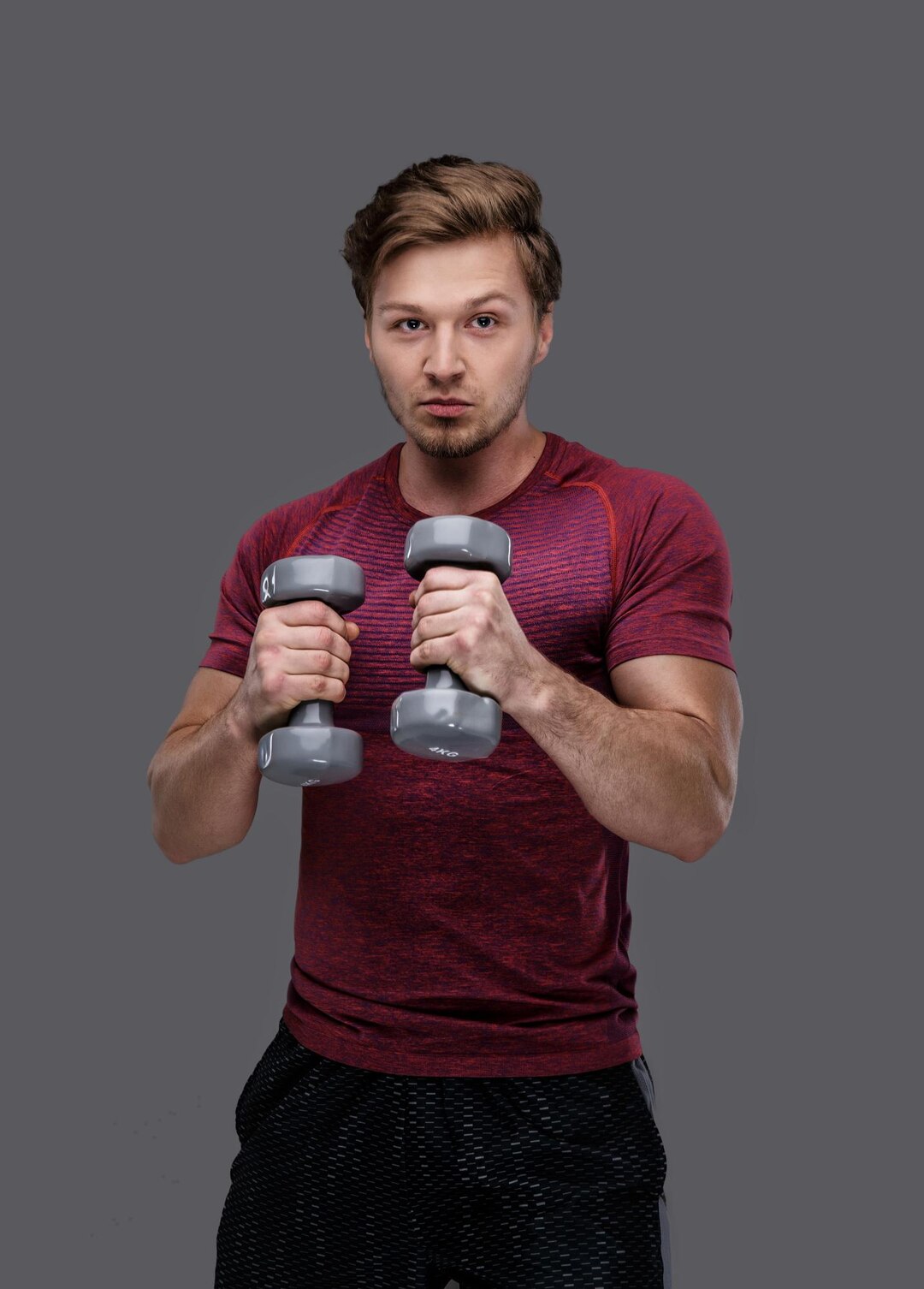sporty-man-red-t-shirt-holds-dumbbells_